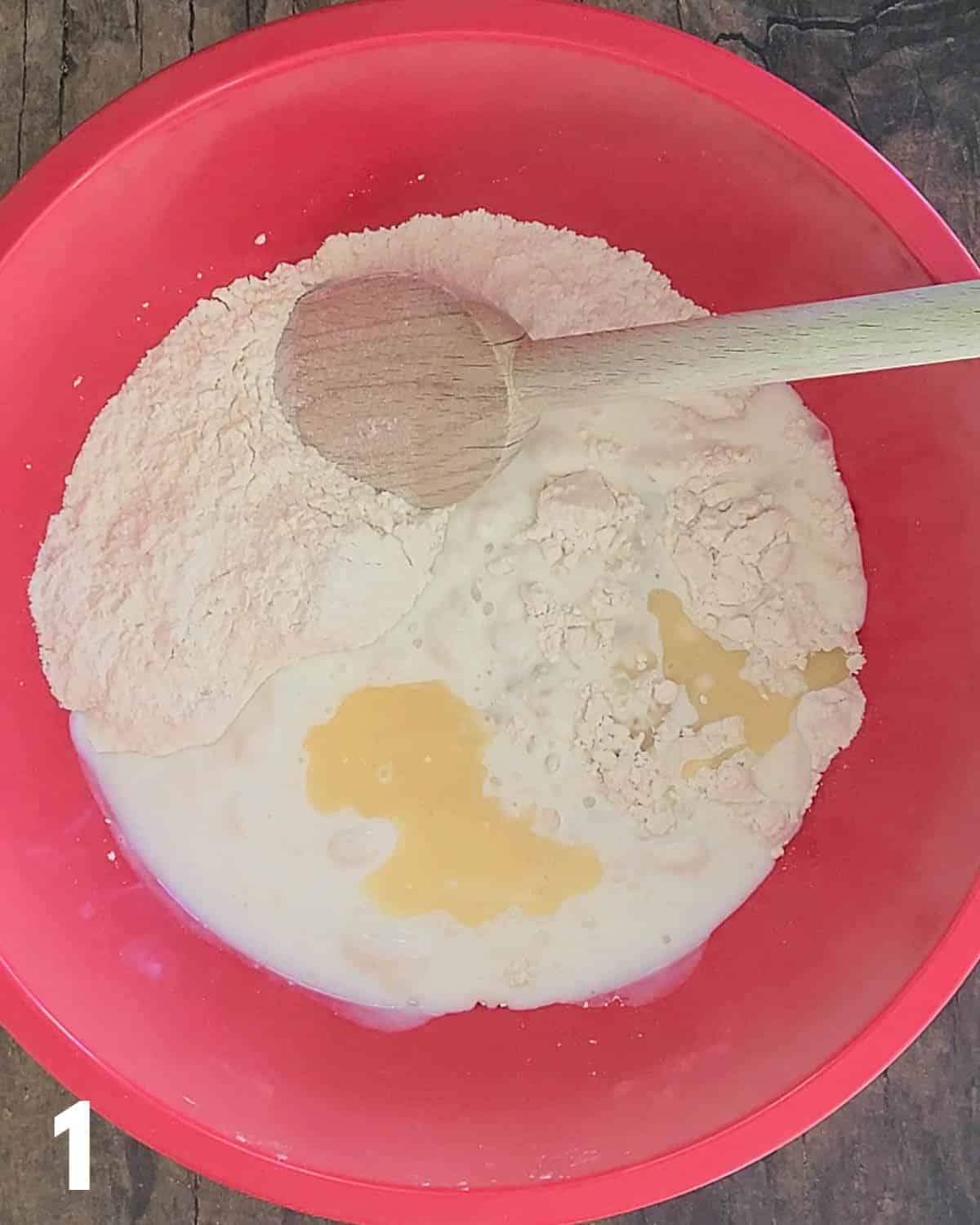 Flour, butter, and buttermilk in a red mixing bowl. 