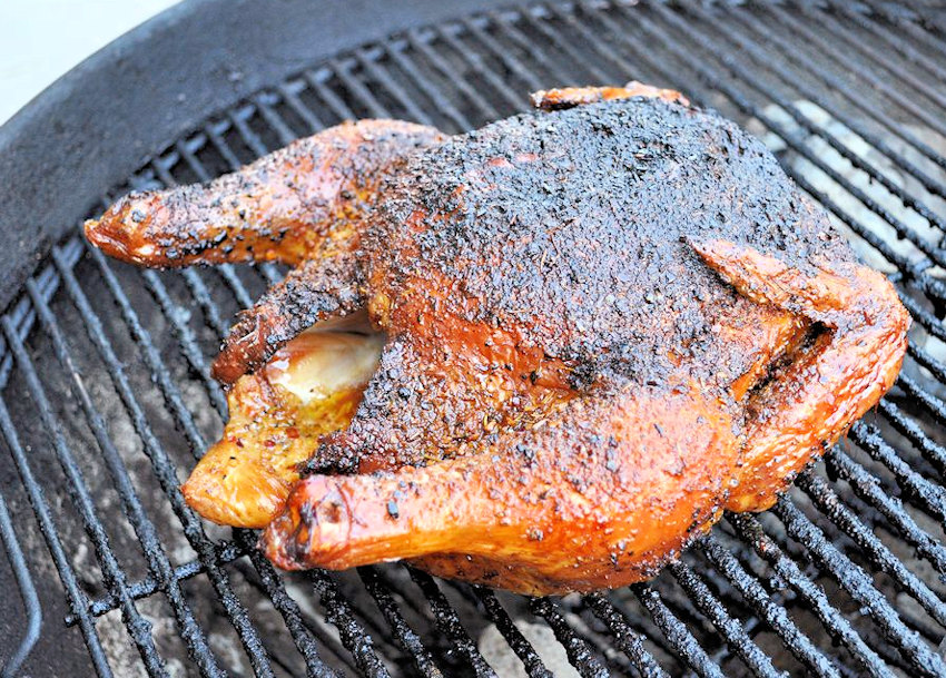 a full chicken being cooked on a Weber bbq