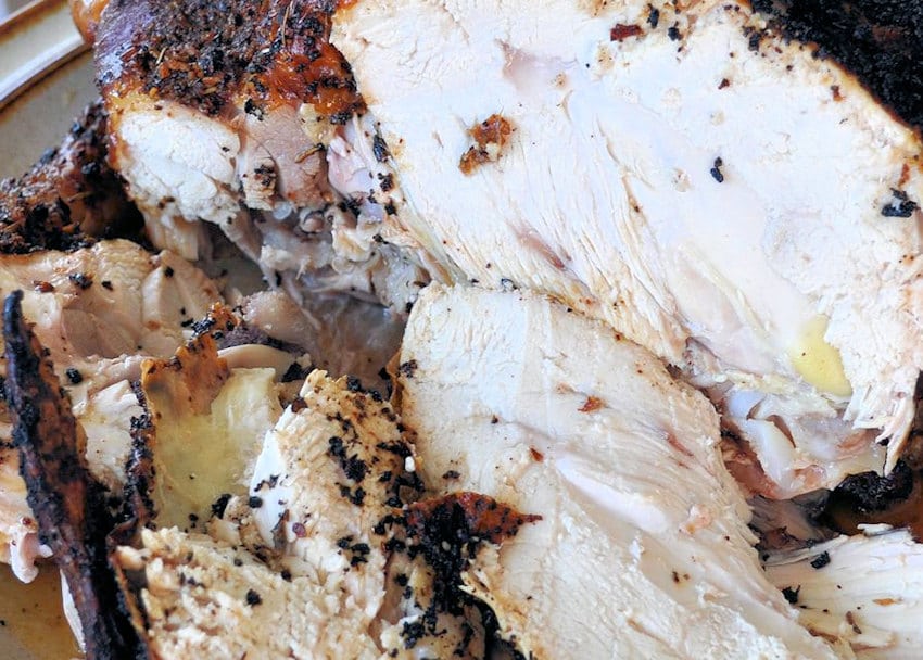a close up photo of a whole, carved, bbq chicken
