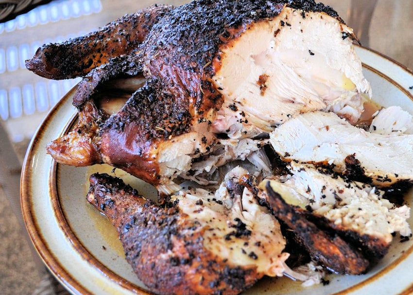 carved up whole chicken on a beige platter
