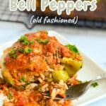 A plate with Stuffed Bell Peppers topped with herbs and a red sauce, featuring a site watermark at the bottom.
