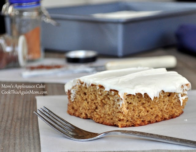 applesauce cake with frosting sitting next to a fork