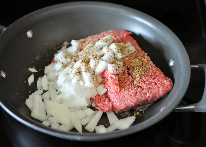 ground beef and onion in a black skillet