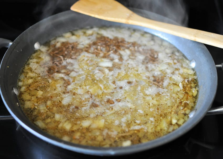 ground beef, onion, and noodles cooking