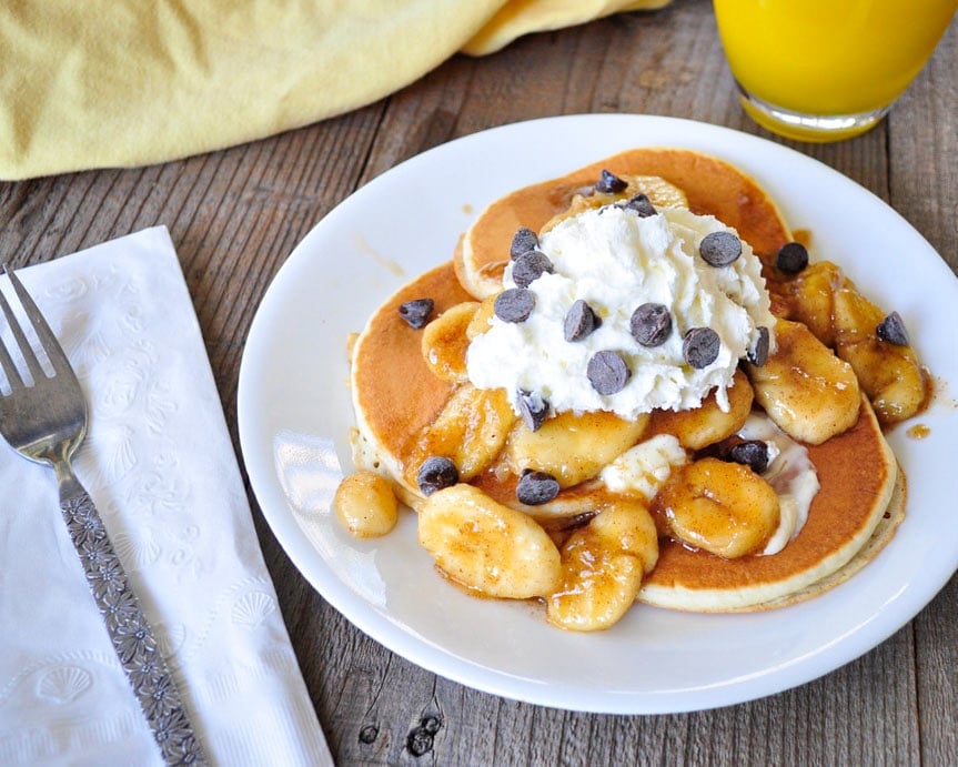 brown sugared bananas on pancakes with whipped cream and chocolate chps