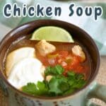 A comforting bowl of traditional Mexican Chicken Soup, garnished with lime, sour cream, and a sprinkle of fresh cilantro.