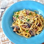mushrooms with pasta being served in a blue bowl.