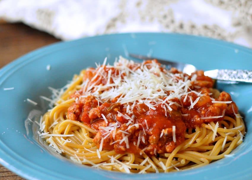 sauce covered spaghetti in a blue bowl