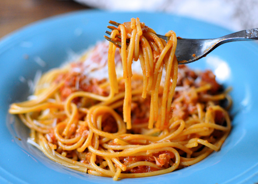 sauce covered spaghetti in a blue bowl