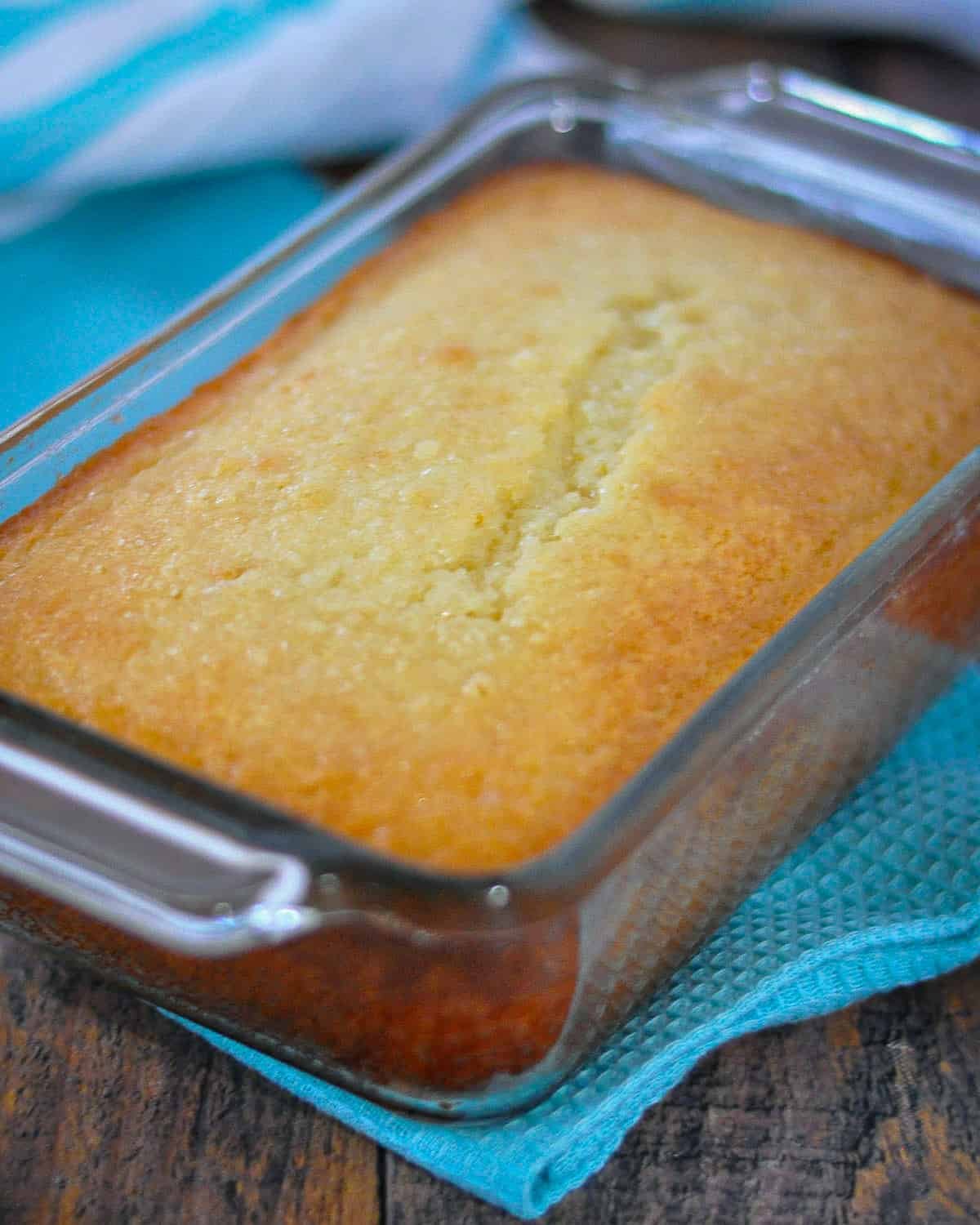 A loaf of just baked lemon bread in a glass baking dish. 