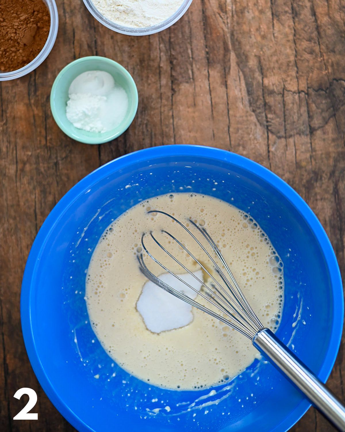 Eggs, milk, and sugar being mixed together in a bowl.