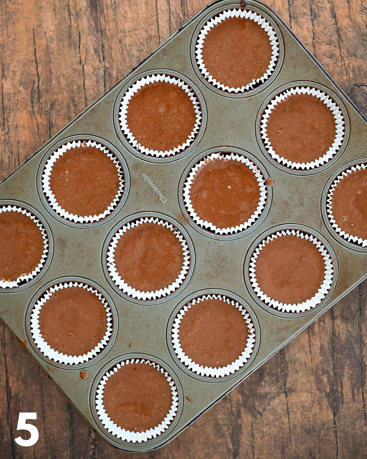 Chocolate cupcake batter pour into a muffin tin.