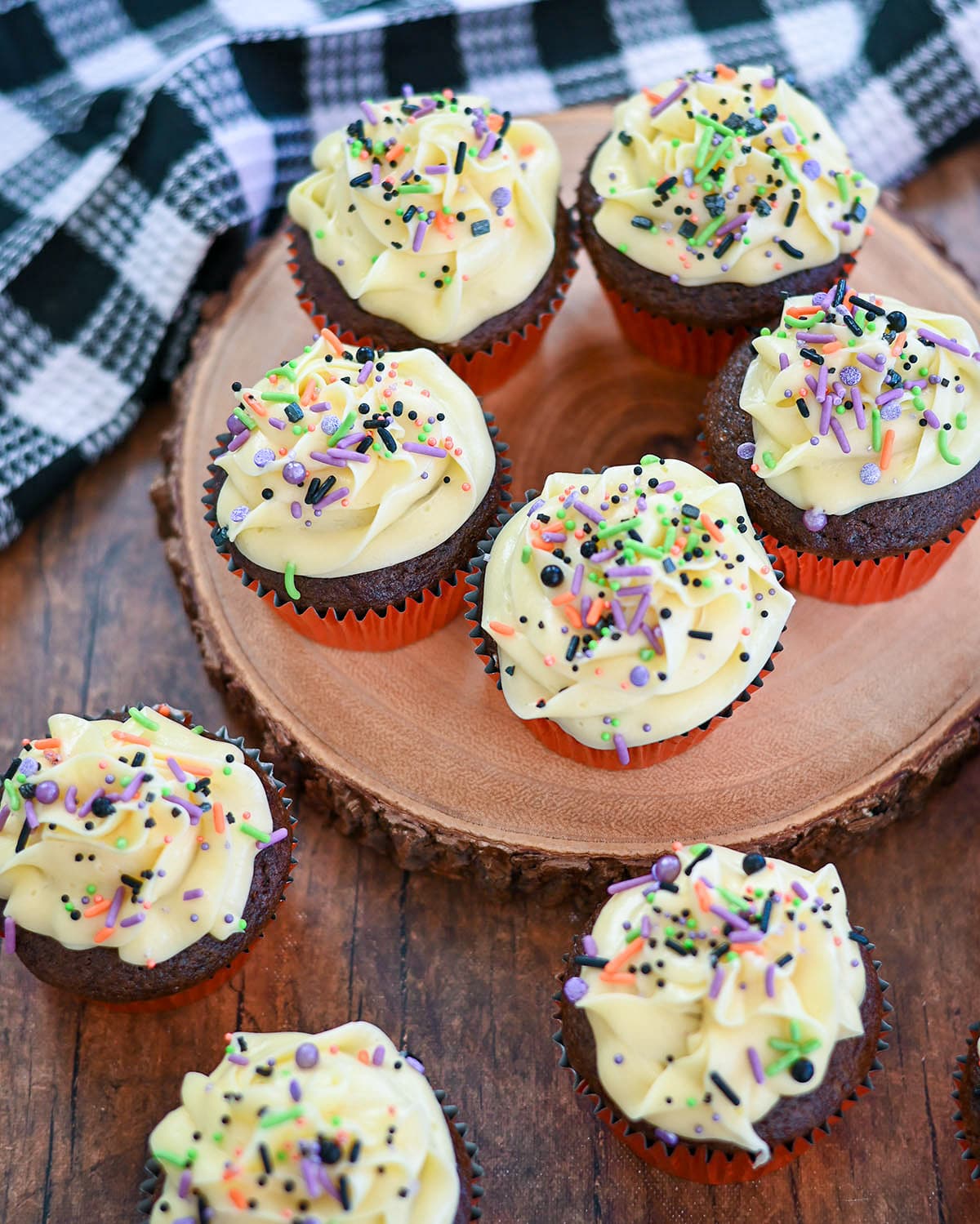 Chocolate cupcakes with butter frosting topped with colorful sprinkles. 