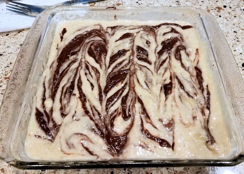 chocolate swirled into banana bread batter in a baking dish