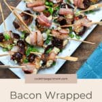 A savory appetizer featuring Cheese Stuffed Dates Wrapped in Bacon, garnished with green onions and served on wooden sticks.