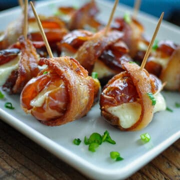 dates stuffed with cheese wrapped in bacon on a plate