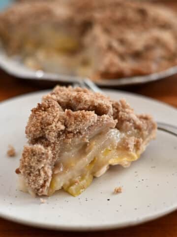 A slice of pear pie on plate with a fork.