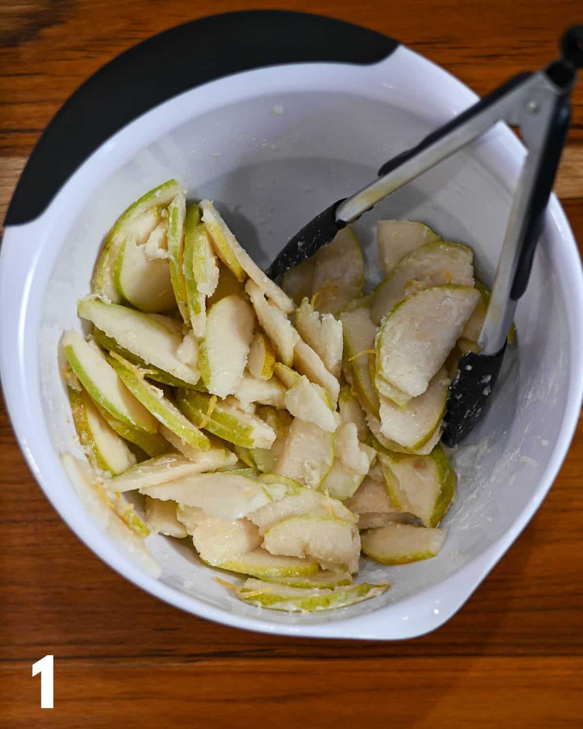 Sliced pears, ginger, lemon and flour in a mixing bowl.