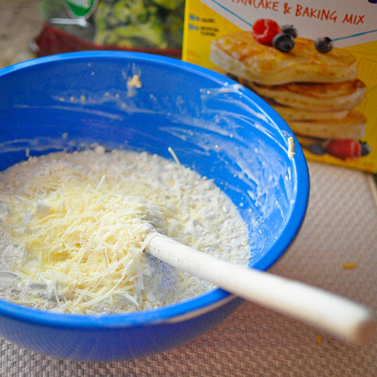 a blue bowl with bisquick, parmesan cheese, and other ingredients. 