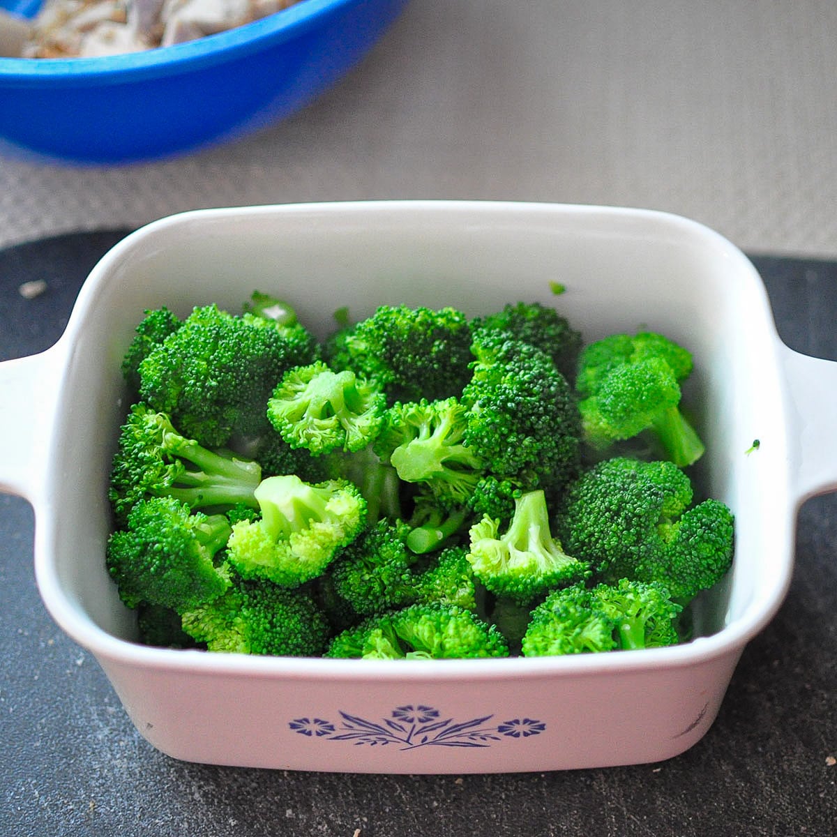 a white dish filled with lightly steamed fresh broccoli.