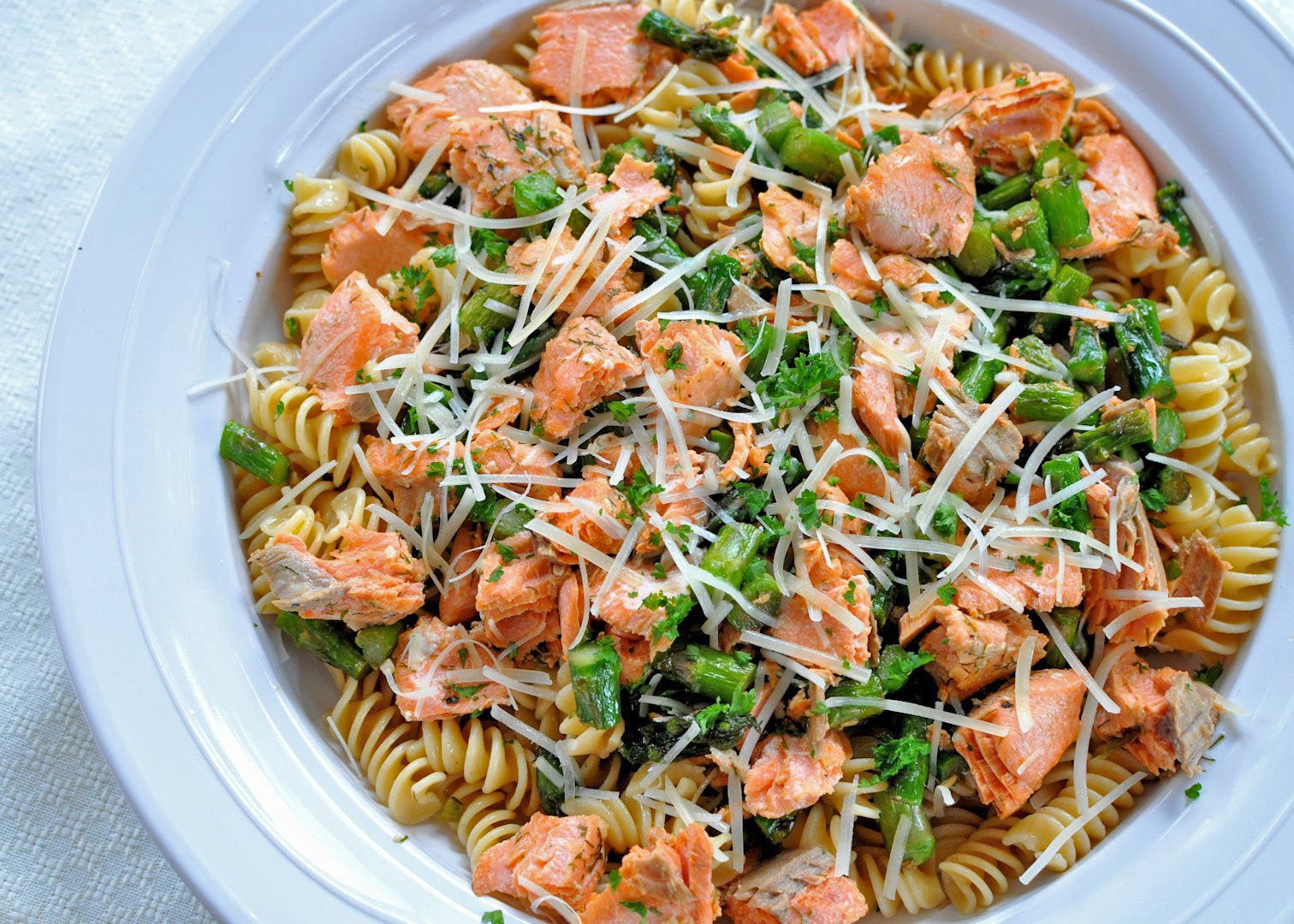 Overhead shot of Salmon with Pasta and Asparagus in a white bowl