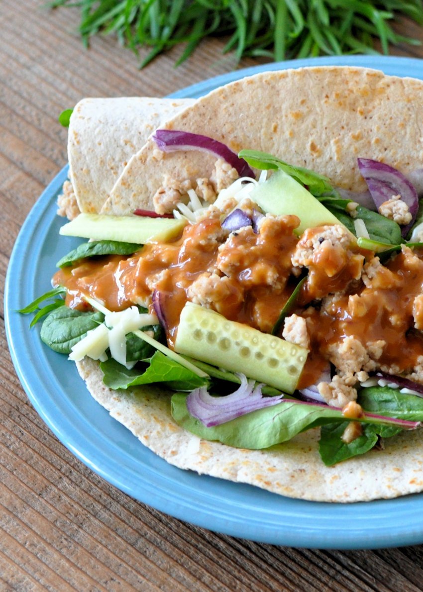 tortilla with cucumber,, lettuce, and ground chicken on a blue plate