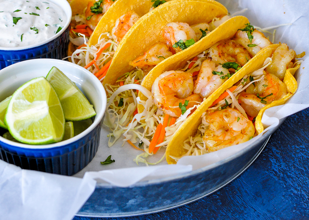 shrimp with cabbage and carrot in a corn tortilla on a tray