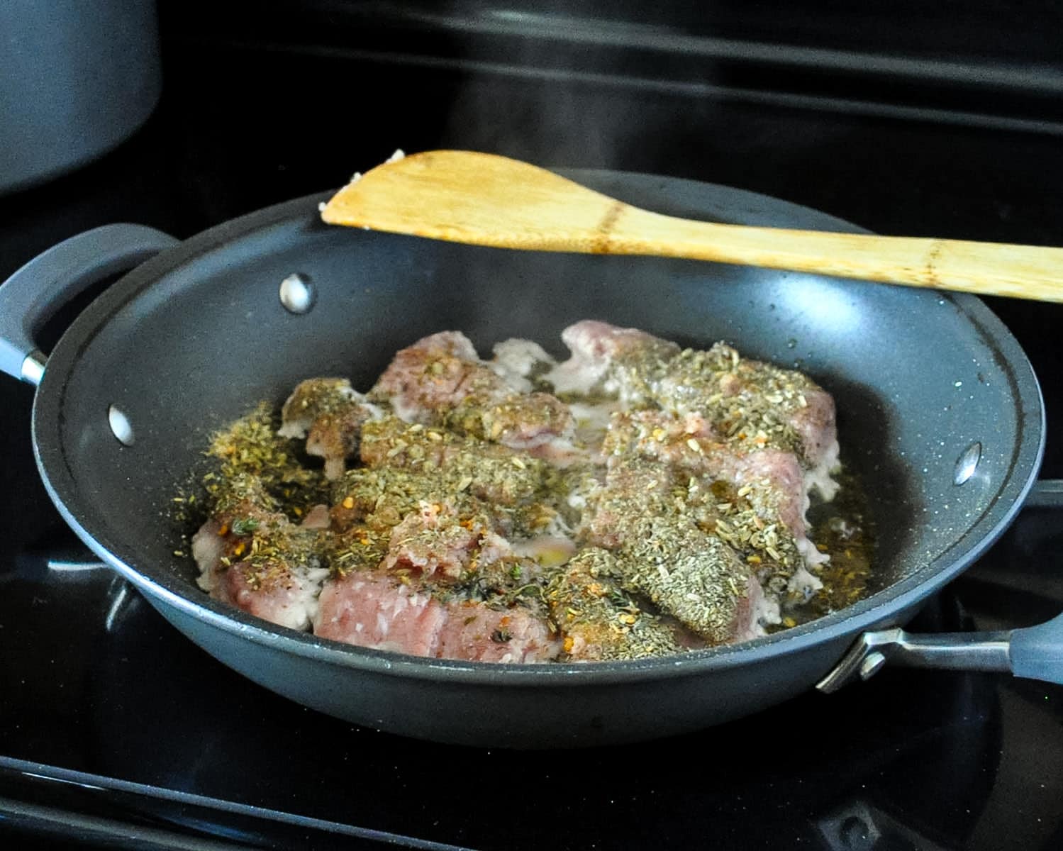 ground turkey and spices cooking in a skillet