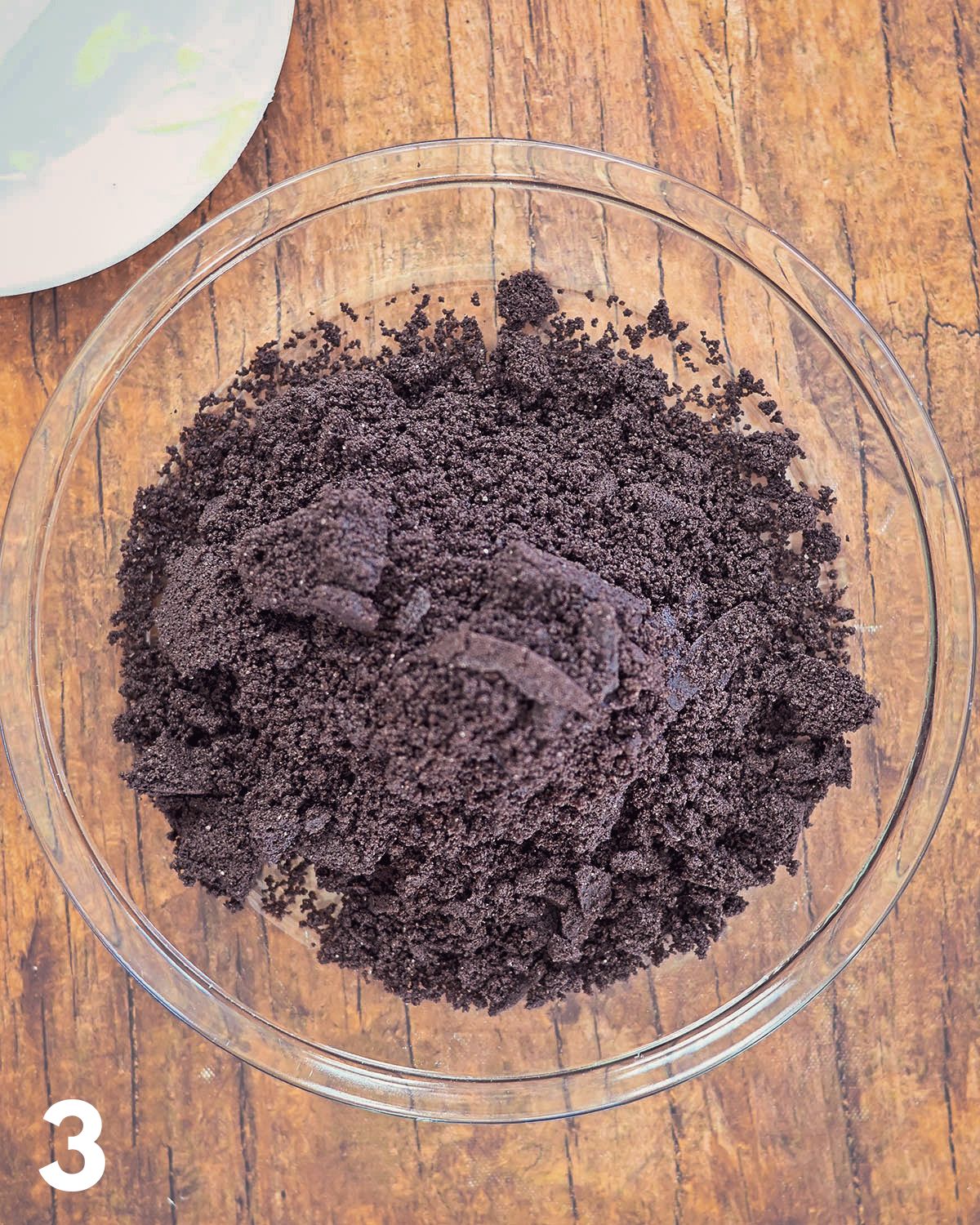 Oreo Cookie crumbs and butter in a pie plate.