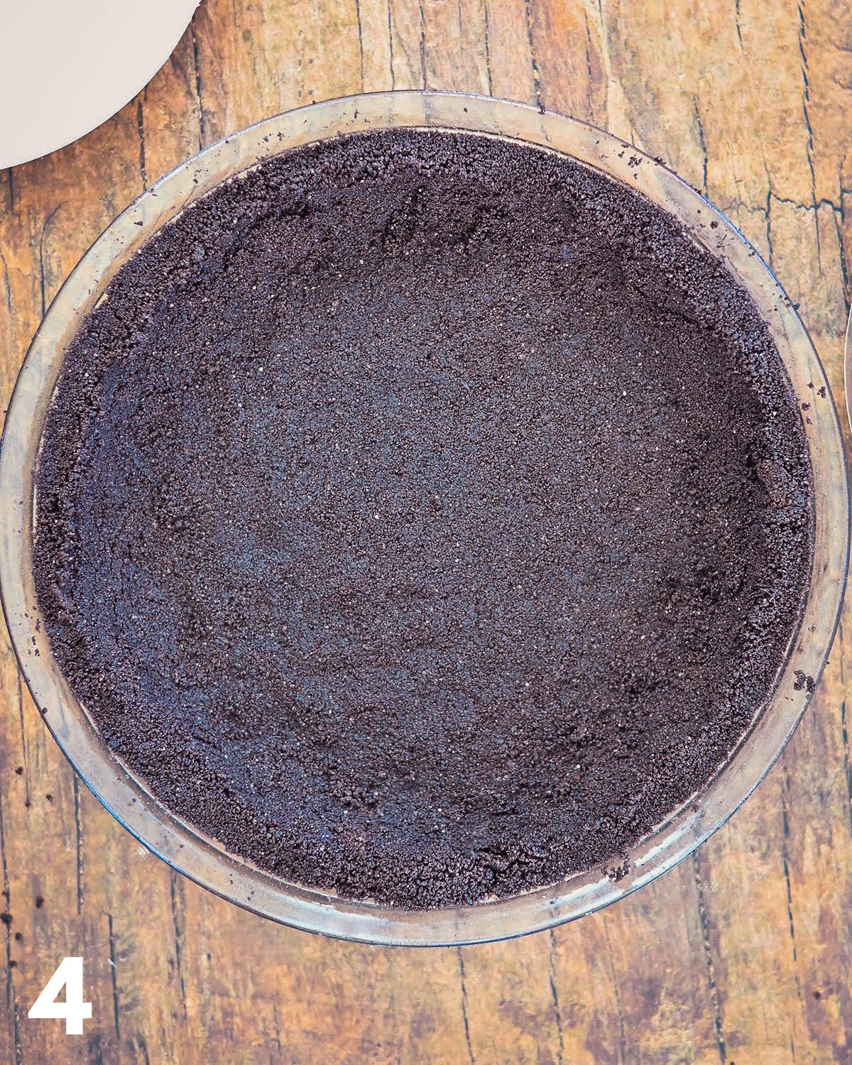 Oreo cookie crust in a pie plate.