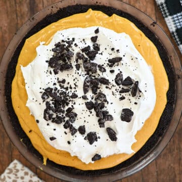 Pumpkin no bake cheesecake with whipped topping and a oreo crust ready to serve.