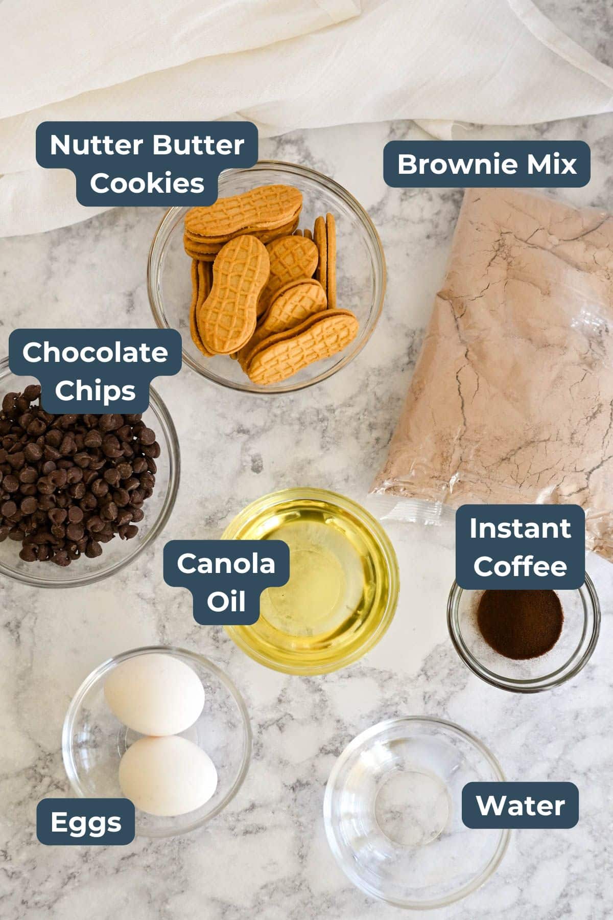 Bowls of Nutter Butter cookies, brownie mix, chocolate chips, canola oil, instant coffee, eggs, and water—everything you need for irresistible Nutter Butter Chocolate Chip Brownies.