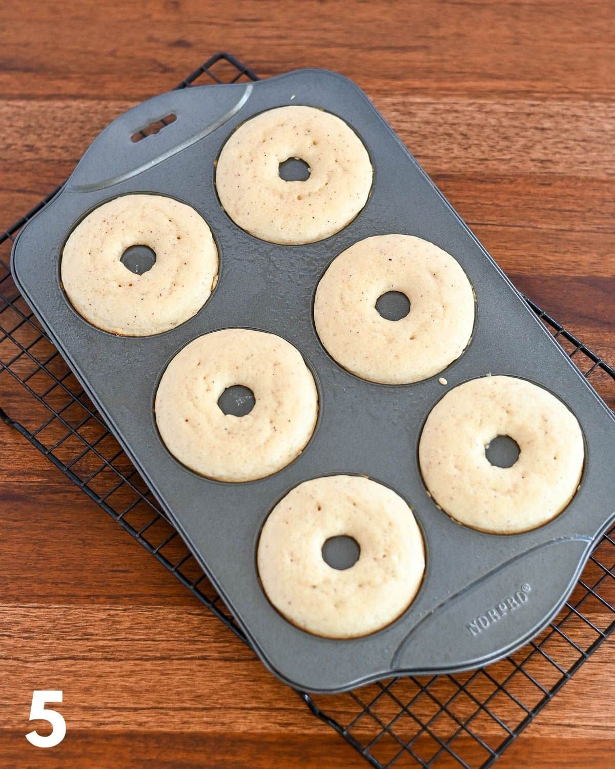 Just baked donuts still in a donut pan. 
