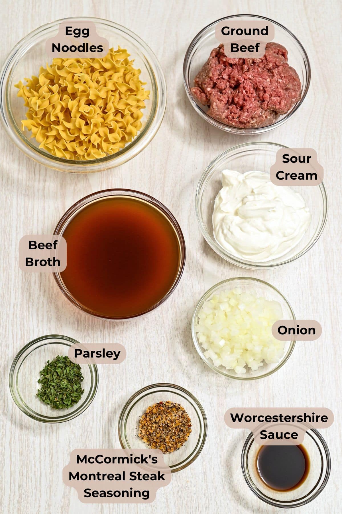 Bowls of egg noodles, ground beef, sour cream, beef broth, onion, parsley, seasoning, and Worcestershire sauce.