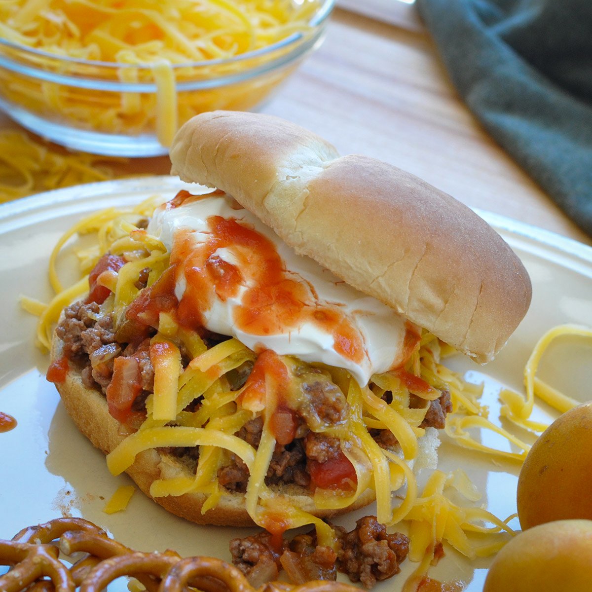 taco meat with salsa, cheese, and sour cream on a bun