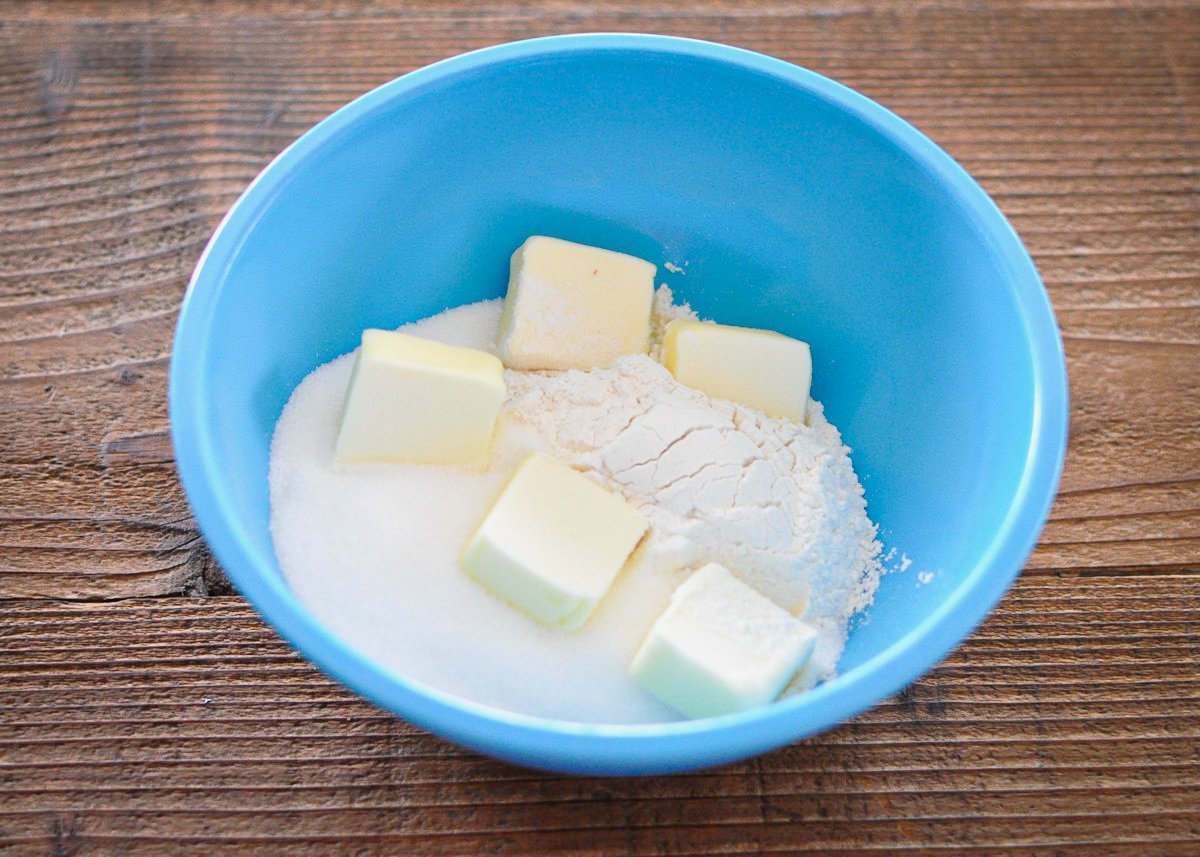 butter, flour, and sugar in a blue bowl to make crumb topping 