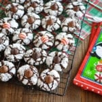 chocolate crinkle cookies with a holiday hershey kiss in the middle on a black rack