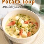 A bowl of homemade potato soup with creamy goodness, enriched by celery and carrots, topped with fresh herbs, sits invitingly beside a green plaid cloth.
