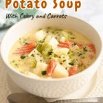 Homemade potato soup brimming with creamy goodness, featuring carrots and celery in a white bowl. It's perfectly nestled on a plate, accompanied by a spoon ready for savoring.