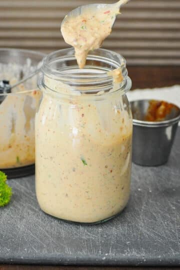 a jar full of chipotle flavored ranch dressing on a black cutting board