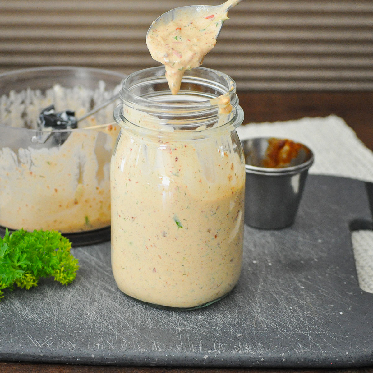 a jar full of chipotle flavored ranch dressing on a black cutting board