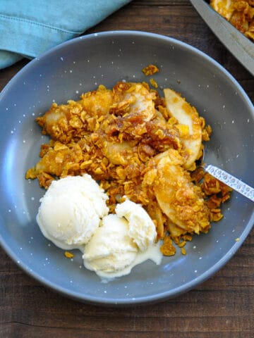 a bowl of apple crisp made with corn flakes and a side of vanilla ice cream