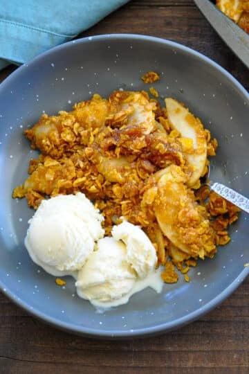 a bowl of apple crisp made with corn flakes and a side of vanilla ice cream