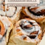 Close-up of iced cocoa cinnamon rolls with a sign describing their buttery chocolate filling.