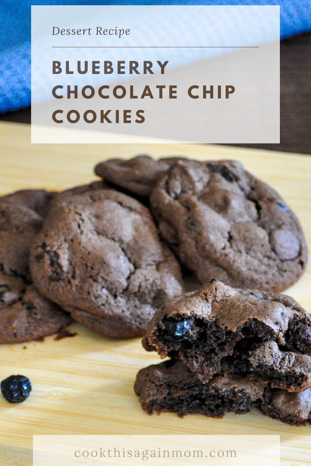 a stack of blueberry chocolate cookies sitting on a bamboo cutting board