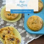 a pineapple muffin split in two laying on a lace table runner next to the pan of muffins and recipe card