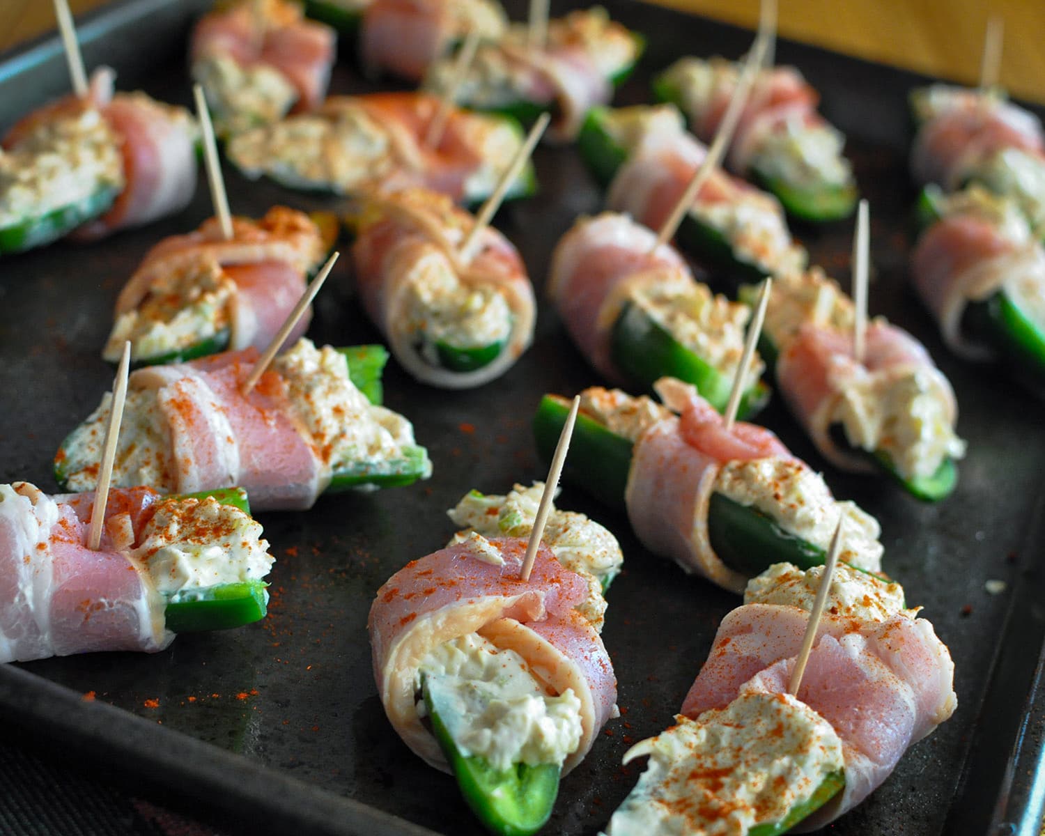 smokey paprika sprinkled on stuffed jalapenos that are ready to be baked