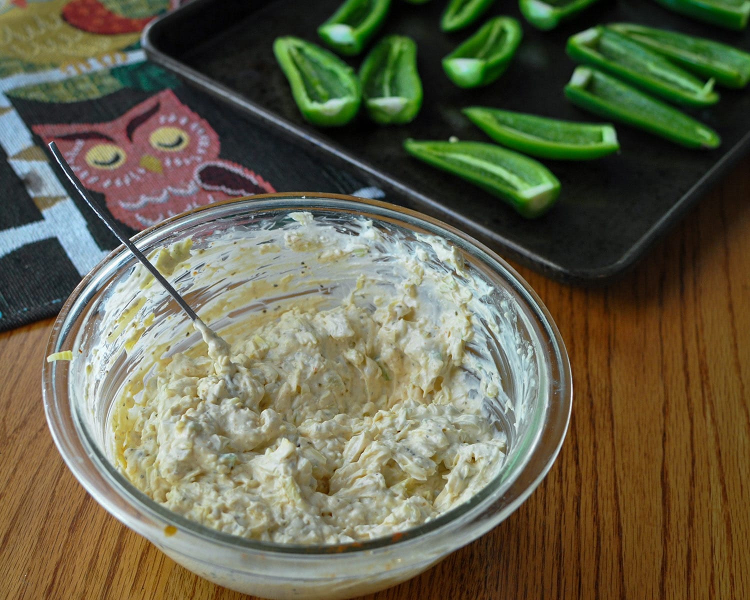 a bowl with cream cheese and artichoke hearts to be used as a filling for jalapenos