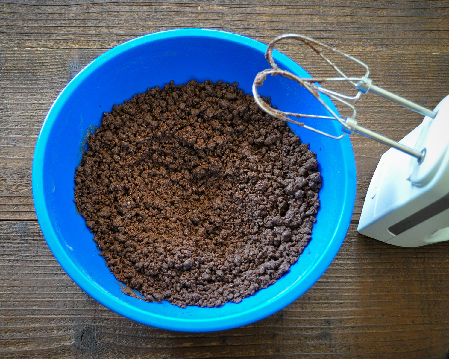 chocolate cake mix in a blue bowl mixed with oil and egg