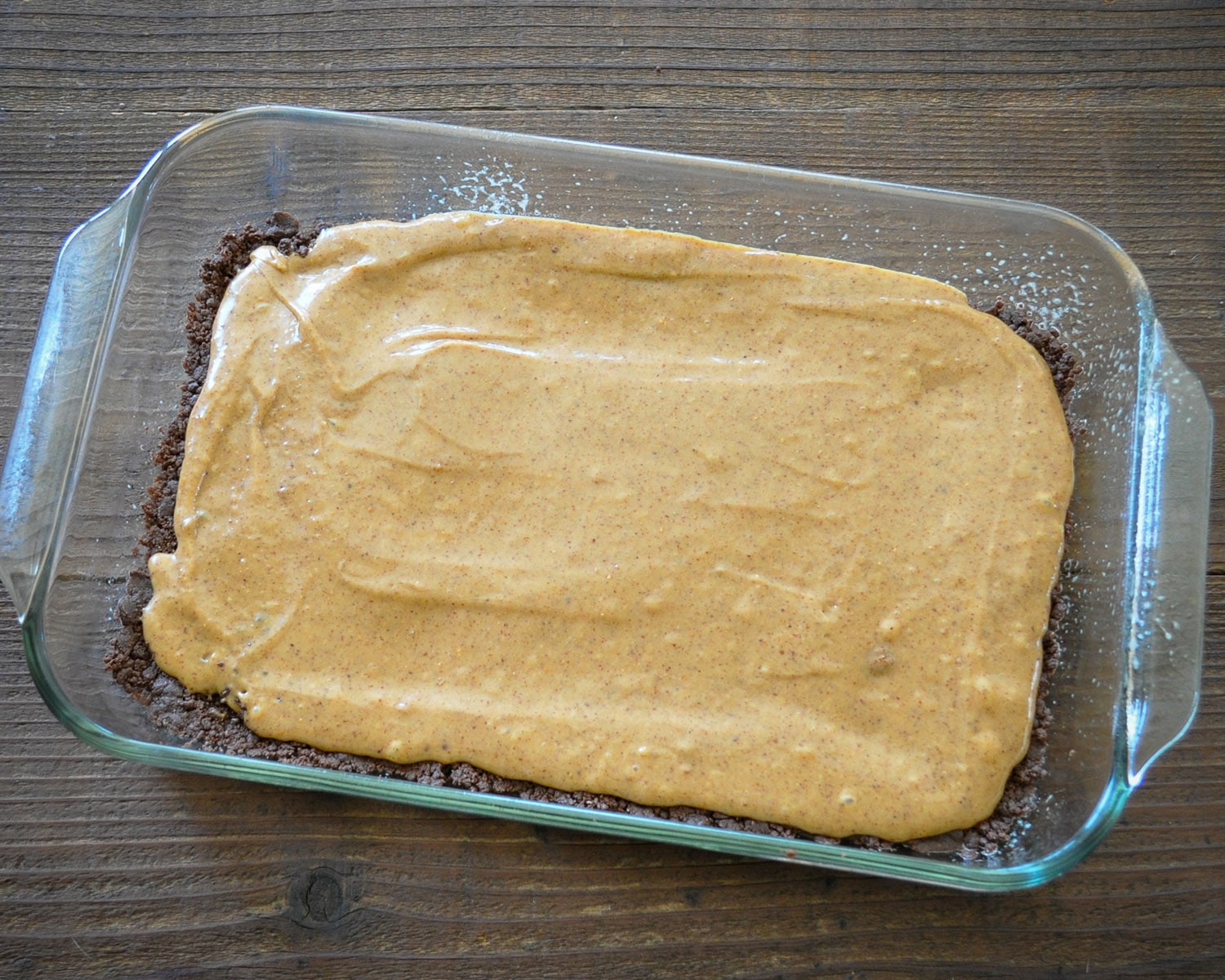 a chocolate dessert bar base in a 13 x 9 dish covered with an almond butter topping